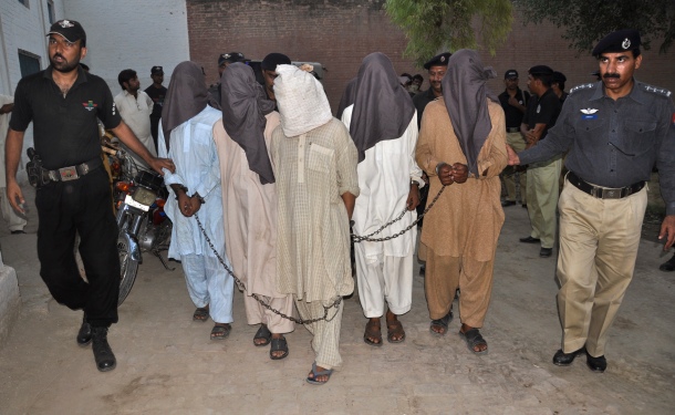 Police escort hooded and detained men to a prison in Bahawalpur
